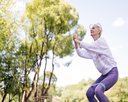Active middle-aged woman stretching in a park